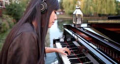 HJ Lim plays piano on a river